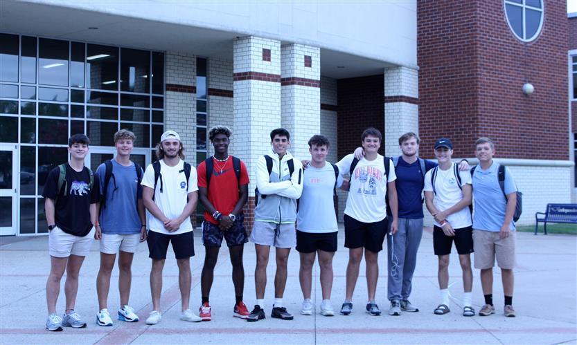 A group of students stands in front of their high school